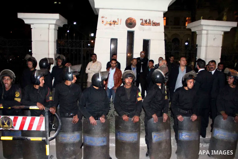 Egyptian security forces stand guard as protesters gather in front of Governorate building in Giza on February 24, 2013, as they closed its doors part of a growing campaign of civil disobedience around the country. A gro...