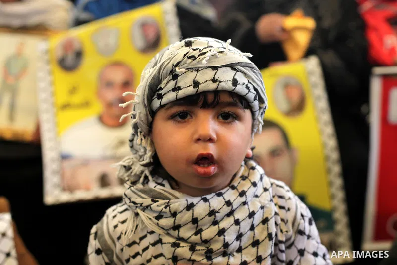 Palestinians hold pictures of prisoners held in the Israeli jails during a protest calling for the release of Palestinian prisoners from Israeli jails in front of the Red cross office in Gaza city, on February 25, 2013....