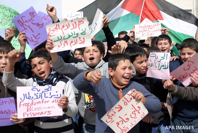 Palestinian students take part in a protest in solidarity with prisoners held in Israeli jails in the West Bank city of Hebron on Feb.25, 2013. The demonstration was held in solidarity with Palestinian prisoner Samer al-...