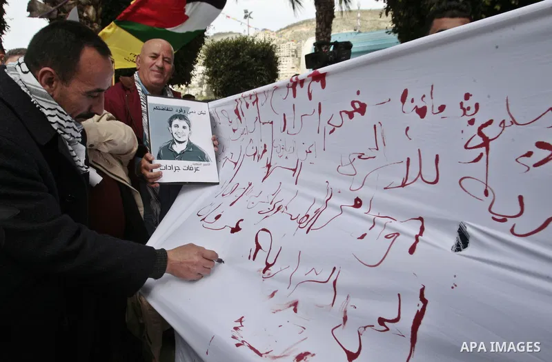 Palestinians write letters in blood on a banner during a demonstration in support of the Palestinian prisoners in Israeli jails, in the city of Nablus, in the occupied West Bank, on February 25, 2013. Protests in support...