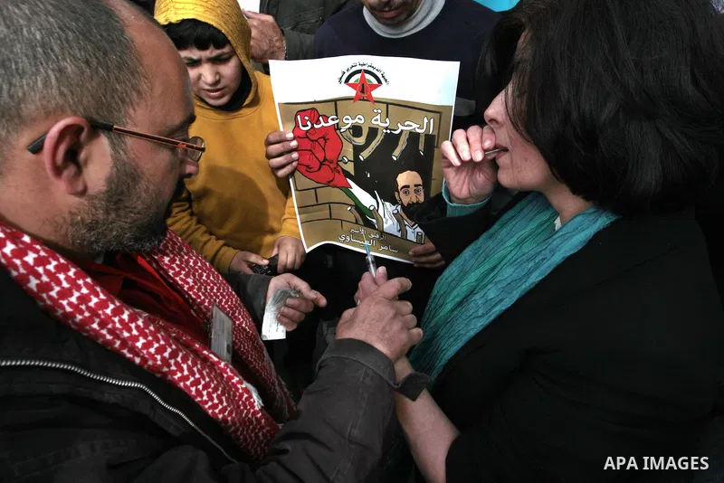 Palestinians write letters in blood on a banner during a demonstration in support of the Palestinian prisoners in Israeli jails, in the city of Nablus, in the occupied West Bank, on February 25, 2013. Protests in support...