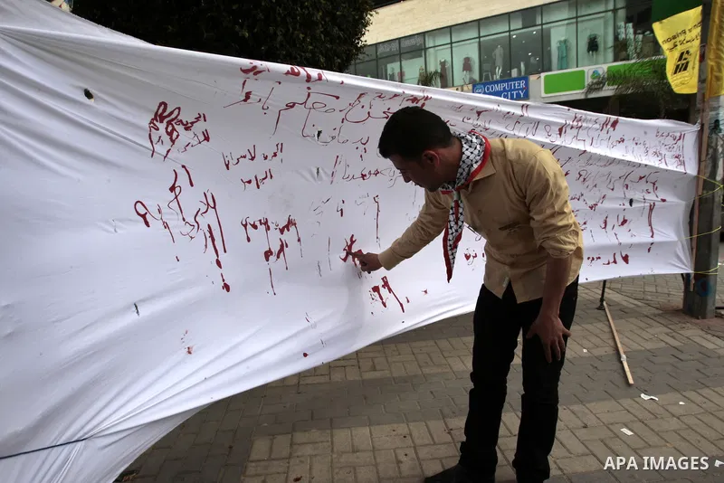 Palestinians write letters in blood on a banner during a demonstration in support of the Palestinian prisoners in Israeli jails, in the city of Nablus, in the occupied West Bank, on February 25, 2013. Protests in support...