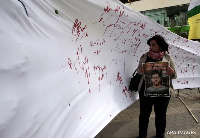 Palestinians write letters in blood on a banner during a demonstration in support of the Palestinian prisoners in Israeli jails, in the city of Nablus, in the occupied West Bank, on February 25, 2013. Protests in support...