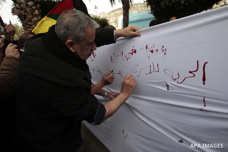 Palestinians write letters in blood on a banner during a demonstration in support of the Palestinian prisoners in Israeli jails, in the city of Nablus, in the occupied West Bank, on February 25, 2013. Protests in support...