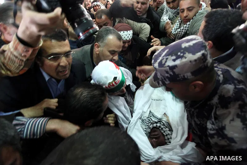Palestinians mourn over the body of Arafat Jaradat mourn during his funeral in the West Bank village of Se'eer, near Hebron February 25, 2013. Jaradat's death in an Israeli jail on Saturday and a hunger strike by four ot...