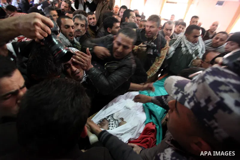 Palestinians mourn over the body of Arafat Jaradat mourn during his funeral in the West Bank village of Se'eer, near Hebron February 25, 2013. Jaradat's death in an Israeli jail on Saturday and a hunger strike by four ot...