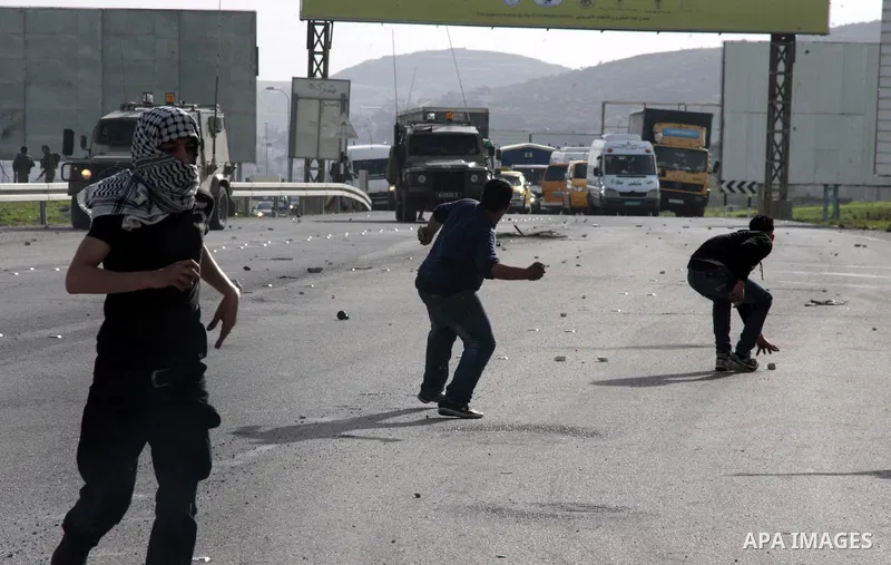 Palestinian protesters throw stones at Israeli border police during clashes at Hawwara military checkpoint near the West Bank city of Nablus, on February 25, 2013 following the death of a Palestinian prisoner held in Isr...