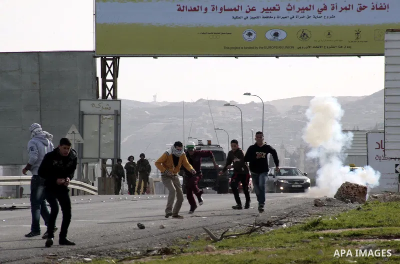 Palestinian protesters throw stones at Israeli border police during clashes at Hawwara military checkpoint near the West Bank city of Nablus, on February 25, 2013 following the death of a Palestinian prisoner held in Isr...