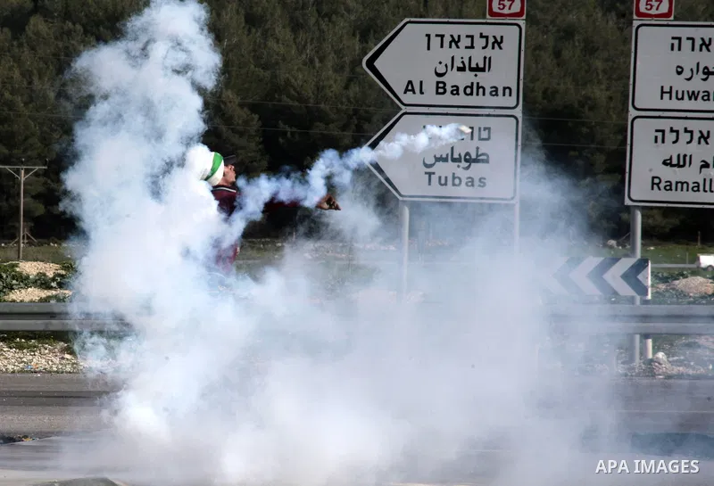 A Palestinian protester throws back a tear gas canister fired by Israeli border police during clashes at Hawwara military checkpoint near the West Bank city of Nablus, on February 25, 2013 following the death of a Palest...