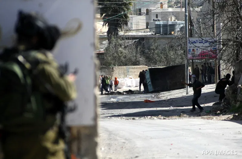 Palestinian protesters throw stones at Israeli security forces during clashes in al-Aroob refugee camp near the West Bank town of Hebron on February 26, 2013. Increased protests in the West Bank after the killing of a Pa...