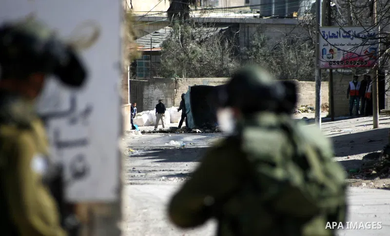 Palestinian protesters throw stones at Israeli security forces during clashes in al-Aroob refugee camp near the West Bank town of Hebron on February 26, 2013. Increased protests in the West Bank after the killing of a Pa...