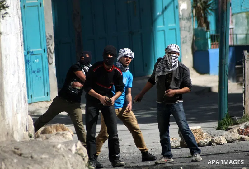 Palestinian protesters throw stones at Israeli security forces during clashes in al-Aroob refugee camp near the West Bank town of Hebron on February 26, 2013. Increased protests in the West Bank after the killing of a Pa...