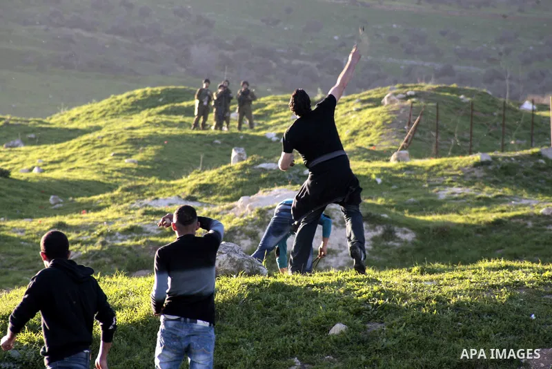 Palestinian protesters throw stones at Israeli security forces during clashes at Hawwara military checkpoint near the West Bank city of Nablus on February 26, 2013. Increased protests in the West Bank after the killing o...