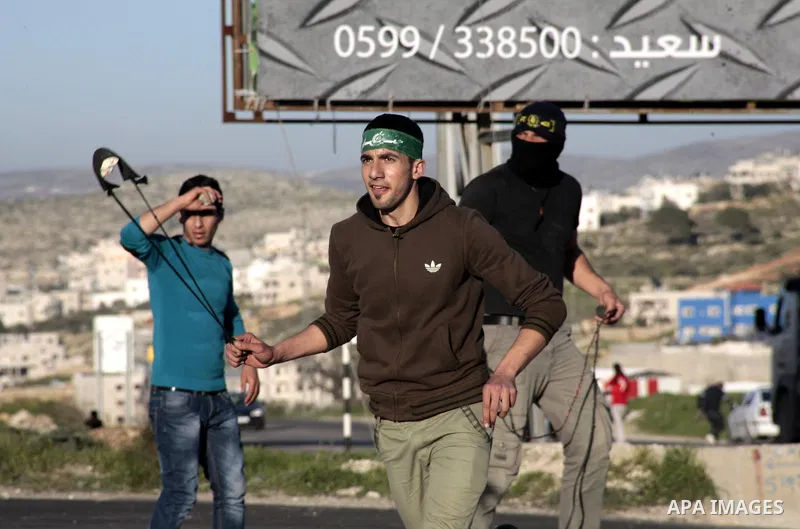 Palestinian protesters hurl stones at Israeli security forces during clashes at Hawwara military checkpoint near the West Bank city of Nablus on February 26, 2013. Increased protests in the West Bank after the killing of...