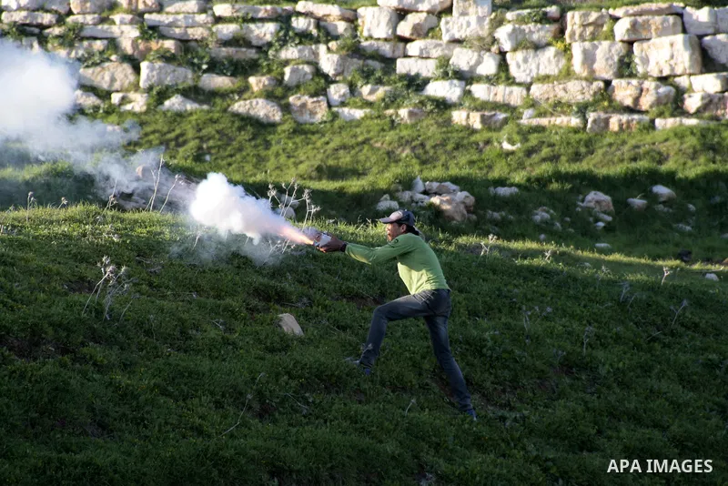 A Palestinian protestor aims sparks from a flare towards Israeli security forces during clashes with Israeli security forces at Hawwara military checkpoint near the West Bank city of Nablus on February 26, 2013. Increase...