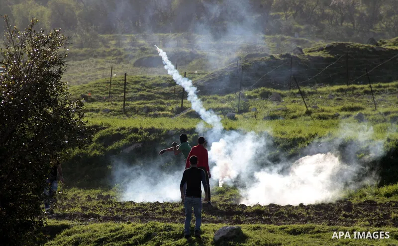 A Palestinian protester throws back a tear gas canister fired by Israeli security forces during clashes at Hawwara military checkpoint near the West Bank city of Nablus on February 26, 2013. Increased protests in the Wes...