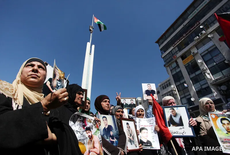 Palestinians carry portraits of prisoners in Israeli jails during a rally organized by the Ministry of prisoners in solidarity with Palestinian prisoners on hunger strike,in the West Bank city of Ramallah on February 27,...
