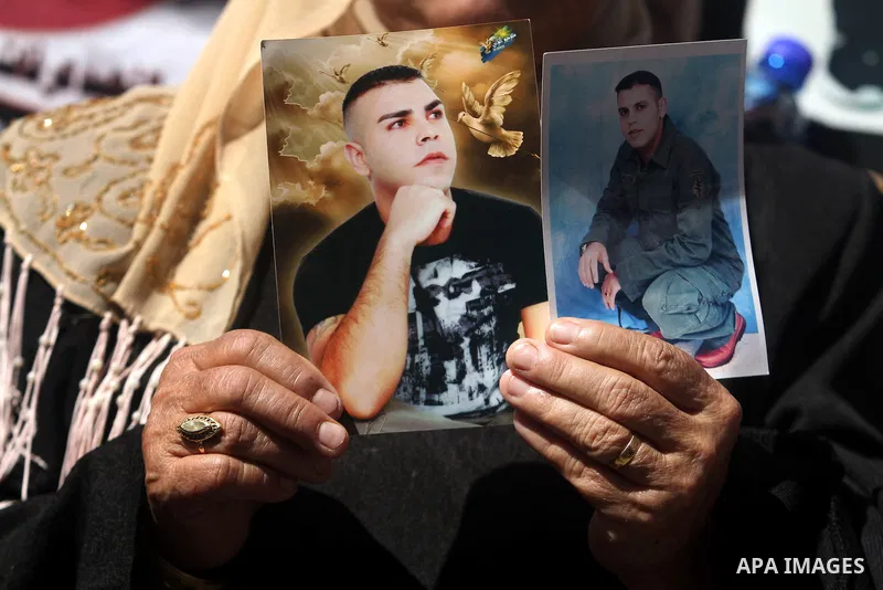 Palestinians carry portraits of prisoners in Israeli jails during a rally organized by the Ministry of prisoners in solidarity with Palestinian prisoners on hunger strike,in the West Bank city of Ramallah on February 27,...