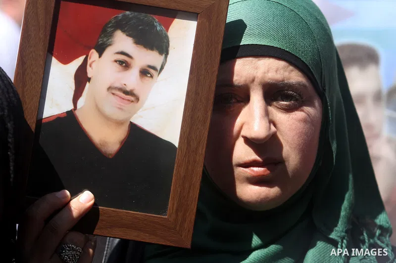 Palestinians carry portraits of prisoners in Israeli jails during a rally organized by the Ministry of prisoners in solidarity with Palestinian prisoners on hunger strike,in the West Bank city of Ramallah on February 27,...