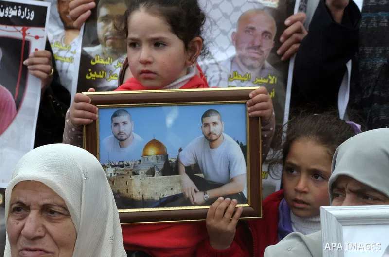 Relatives of Palestinian prisoners jailed in Israeli prisons hold their portraits during a protest in front of Red Cross office in Jerusalem, on 28 February 2013, in support of Palestinian prisoners on hunger strike. Pho...
