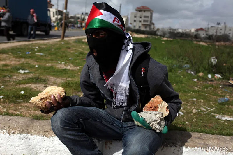 A Palestinian protester carries rocks to throw at Israeli security forces during clashes near Israeli military prison Ofer, south of the West Bank city of Ramallah, 28 February 2013. Hunger strikes by Palestinians in Isr...