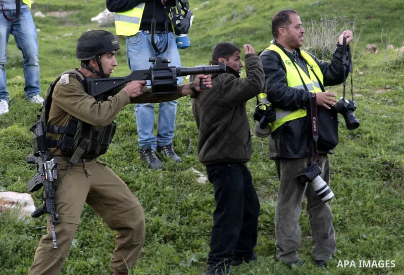 An Israeli soldier fires tear gas during clashes with Palestinian protesters near Huwwara checkpoint, near Nablus, West Bank, 28 February 2013. Hunger strikes by Palestinians in Israeli prisons have sparked clashes throu...