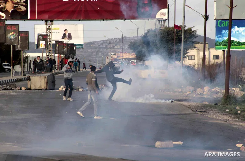 A Palestinian protester kicks back a tear gas canister fired by Israeli security forces during clashes near Huwwara checkpoint, near the West Bank city of Nablus, 28 February 2013. Hunger strikes by Palestinians in Israe...