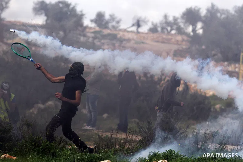 A Palestinian protester uses a racket to back a tear gas fired by Israeli soldiers during clashes next the Jewish settlement of Kereat Saifer, 01 March 2013. The residents of Bilin, west of Ramallah, marked eight years o...