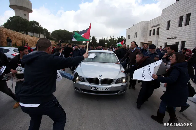 Palestinian students from Birzeit University attack the vehicle of Vincent Finn, British Consul General in Jerusalem, after he was forced to leave Birzeit University Campus in the West Bank city of Ramallah on March 5, 2...