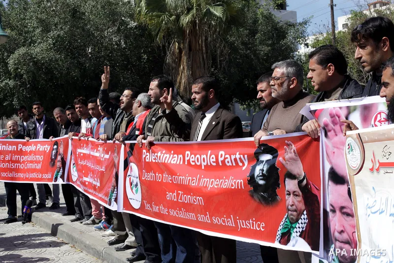 Palestinian factions hold portraits of late Venezuelan president Hugo Chavez during a rally in the Square of the unknown Soldier in Gaza city on march 07, 2013. Chavez died on 05 March from complications related to cance...