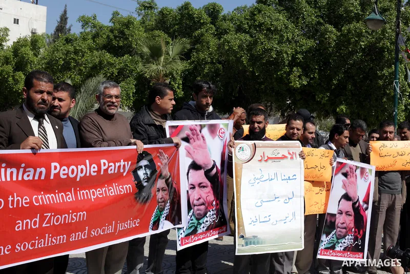 Palestinian factions hold portraits of late Venezuelan president Hugo Chavez during a rally in the Square of the unknown Soldier in Gaza city on march 07, 2013. Chavez died on 05 March from complications related to cance...