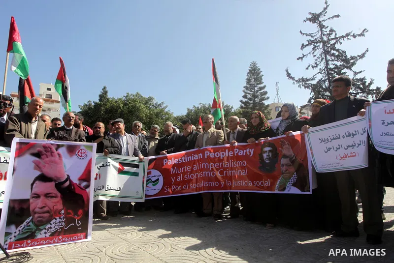 Palestinian factions hold portraits of late Venezuelan president Hugo Chavez during a rally in the Square of the unknown Soldier in Gaza city on march 07, 2013. Chavez died on 05 March from complications related to cance...