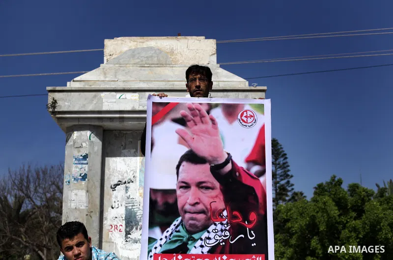 Palestinian factions hold portraits of late Venezuelan president Hugo Chavez during a rally in the Square of the unknown Soldier in Gaza city on march 07, 2013. Chavez died on 05 March from complications related to cance...