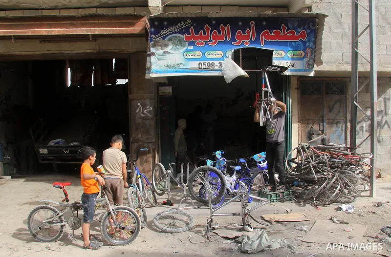 Khamis al-Burdini, 15, a Palestinian youth repairs bicycles at his workshop in Gaza city, on March 13, 2013. al-Burdini opened his workshop 3 years ago after leaving his school to provide his poor family . Photo by Ezz a...