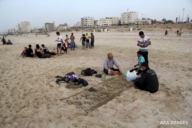 Palestinian children enjoy playing in the sea at Gaza beach during hot weather in Gaza city, March 15, 2013. The temperature of the Gaza strip reaches more than 30 degrees Celsius, Gazans escape to the beach and out from...