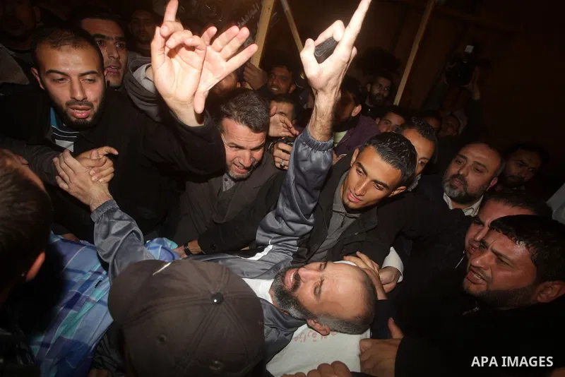 Palestinians carry freed Palestinian prisoner Ayman Sharawna on a stretcher as he gestures upon his arrival to al-Shifa Hospital in Gaza City March 17, 2013. The 36-year-old Ayman Sharawna arrived to Gaza after more than...
