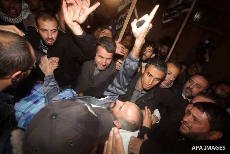 Palestinians carry freed Palestinian prisoner Ayman Sharawna on a stretcher as he gestures upon his arrival to al-Shifa Hospital in Gaza City March 17, 2013. The 36-year-old Ayman Sharawna arrived to Gaza after more than...