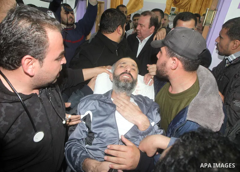 Palestinians carry freed Palestinian prisoner Ayman Sharawna on a stretcher as he gestures upon his arrival to al-Shifa Hospital in Gaza City March 17, 2013. The 36-year-old Ayman Sharawna arrived to Gaza after more than...