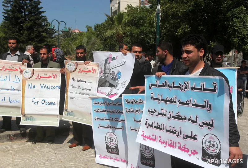 Palestinians hold placards during a demonstration against the visit of US President Barack Obama to the Palestinian territories. in Gaza city, on March 20, 2013. Obama is visiting Israel and the Palestinian Territories f...