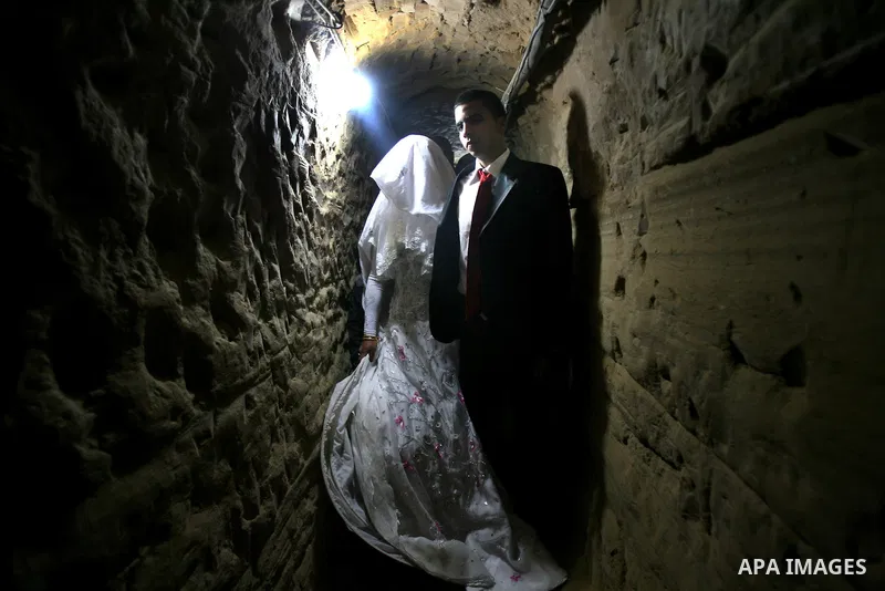 A 21-year-old Palestinian groom Imad, walks with his bride Manal, 21-year-old, in a smuggling tunnel between the southern Gaza Strip and Egypt in the border town of Rafah on March 21, 2013. Imad forced to marry his Egypt...
