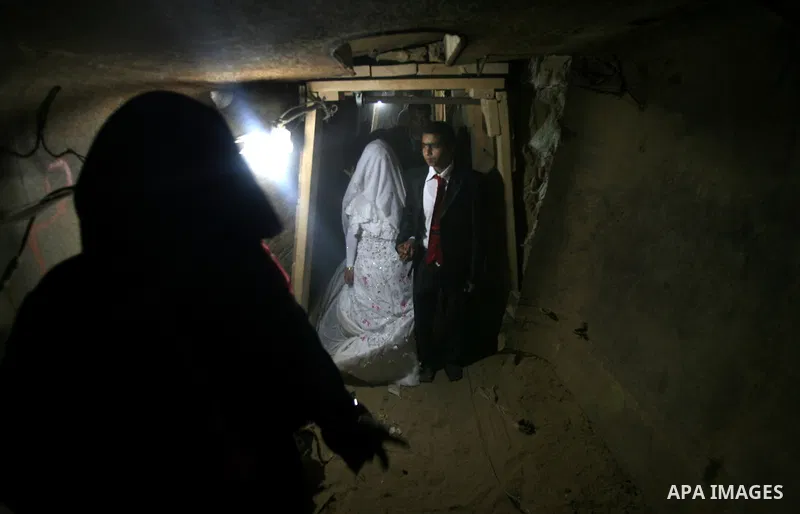A 21-year-old Palestinian groom Imad, walks with his bride Manal, 21-year-old, in a smuggling tunnel between the southern Gaza Strip and Egypt in the border town of Rafah on March 21, 2013. Imad forced to marry his Egypt...