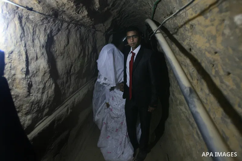 A 21-year-old Palestinian groom Imad, walks with his bride Manal, 21-year-old, in a smuggling tunnel between the southern Gaza Strip and Egypt in the border town of Rafah on March 21, 2013. Imad forced to marry his Egypt...