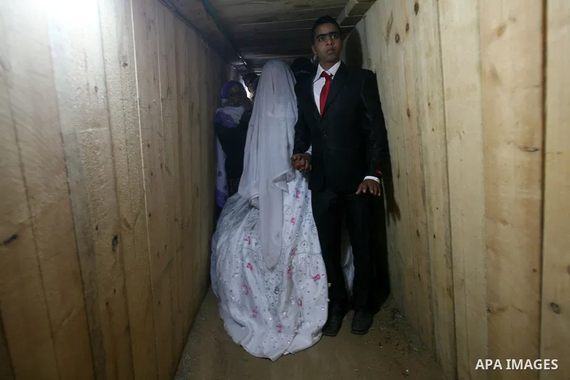 A 21-year-old Palestinian groom Imad, walks with his bride Manal, 21-year-old, in a smuggling tunnel between the southern Gaza Strip and Egypt in the border town of Rafah on March 21, 2013. Imad forced to marry his Egypt...