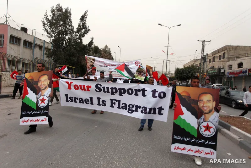 Palestinain protester wave flags during a protest in the Dheisheh refugee camp, near the West Bank city of Bethlehem on 22 March 2013, against the visit of US President Barack Obama to Bethlehem. Photo by Issam Rimawi