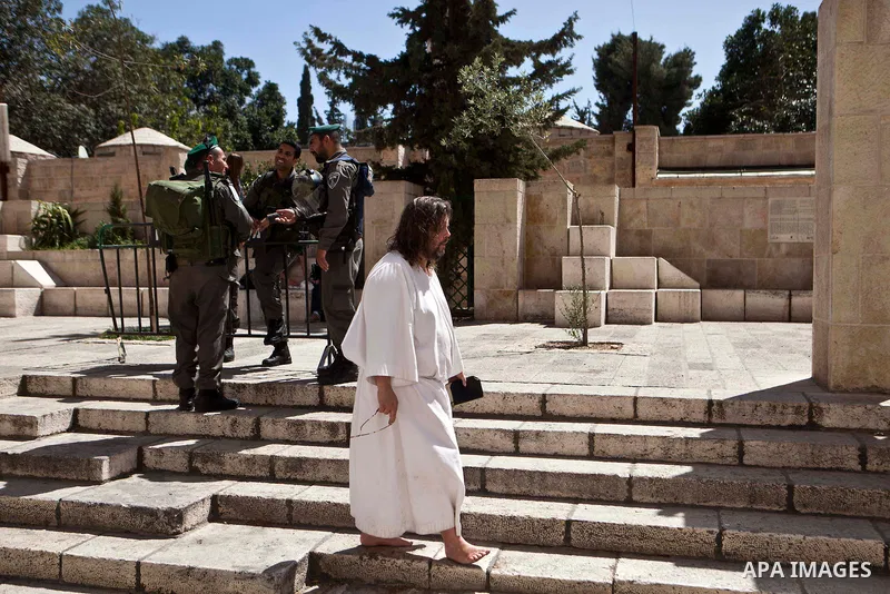 A Christian man walks past Israeli soldiers during the Good Friday procession on on March 29, 2013 in Jerusalem's Old City. Good Friday is celebrated by Christians throughout the world as the day Christ was crucified on...