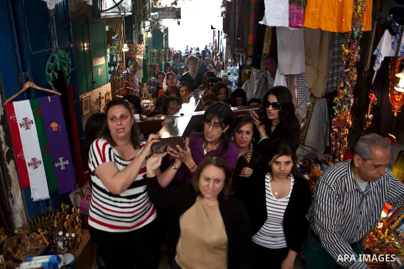 Crowded streets as Palestinian Catholics carry a large wooden cross on the Via Dolorosa during the Good Friday procession on on March 29, 2013 in Jerusalem's Old City. Good Friday is celebrated by Christians throughout t...