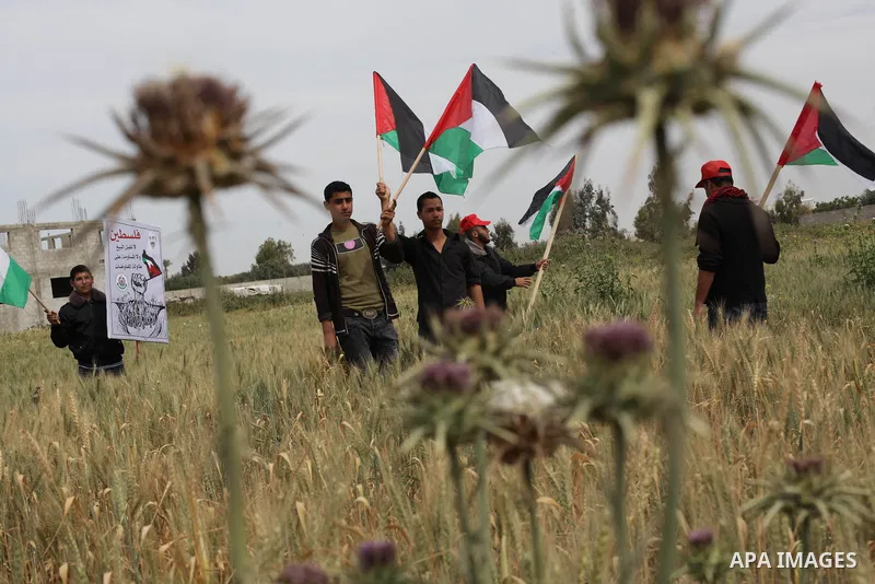 Palestinians wave their national flag during a protest in Beit Hanun, northern Gaza Strip, on March 30, 2013. Land Day commemorates the death of six Arab Israeli protesters at the hands of Israeli troops during mass prot...