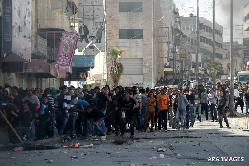 Palestinian protesters throw stones at Israeli soldiers during clashes in the West Bank city of Hebron 2 April 2013, after the news of the death of Maysara Abu Hamdiyeh in the Israeli Soroka hospital. Reports state that...