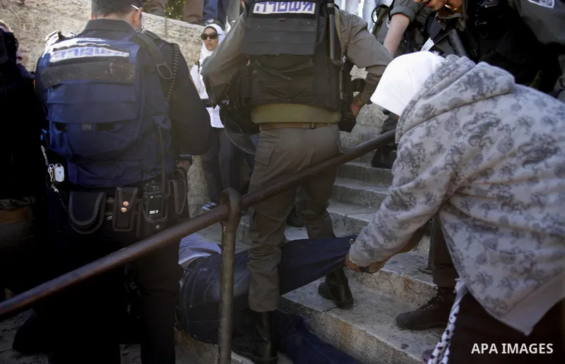 Palestinian hold-up pictures of Maisara Abu Hamdiyeh, a Israeli security arrest a Palestinian man as clashes broke out following the death of a Palestinian prisoner being held in an Israeli jail on April 2, 2013, at the...