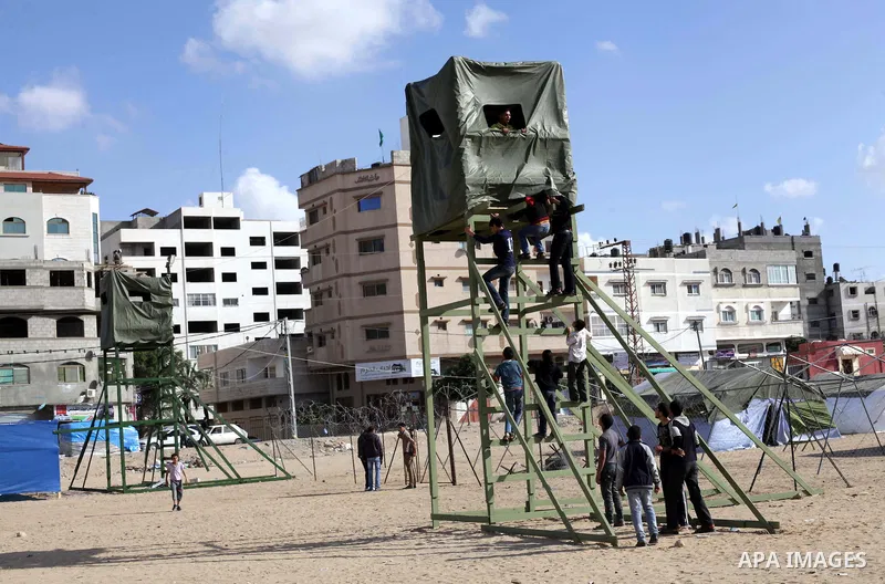 Palestinians climb on a military control tower at a site of an old prison managed by Israeli occupation known as al-Saraya, in Gaza city on April 04, 2013. Palestinian former prisoners at al-Saraya prison set up tents an...
